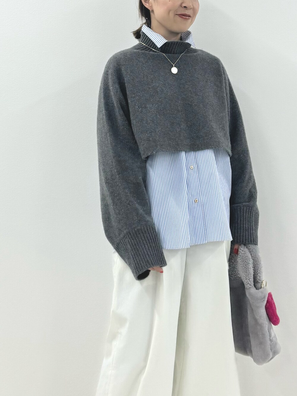 グレー系のニット/セーター、ブルー系のシャツ/ブラウス、ホワイト系のその他パンツを着用したレディースの秋コーディネートの5枚目の写真