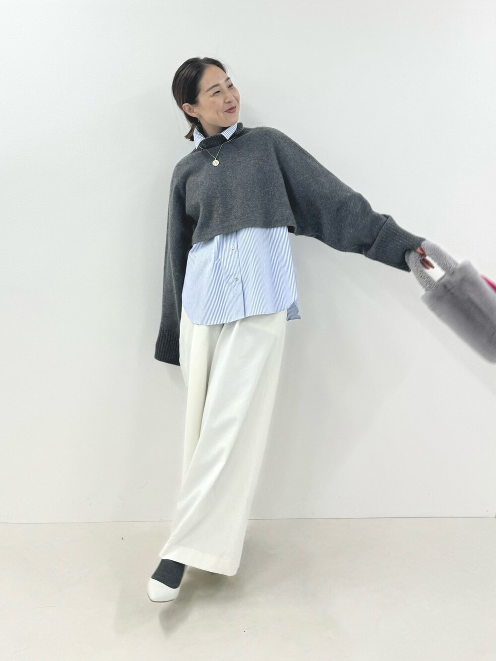グレー系のニット/セーター、ブルー系のシャツ/ブラウス、ホワイト系のその他パンツを着用したレディースの秋コーディネートの7枚目の写真