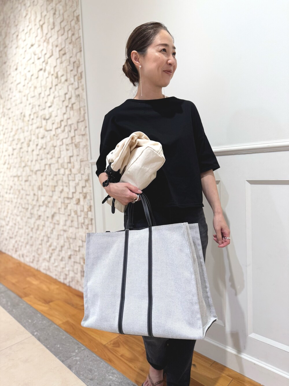 ブラック系のTシャツ/カットソー、ホワイト系のショルダーバッグ、ブラック系のデニムパンツを着用したレディースの夏コーディネートの6枚目の写真