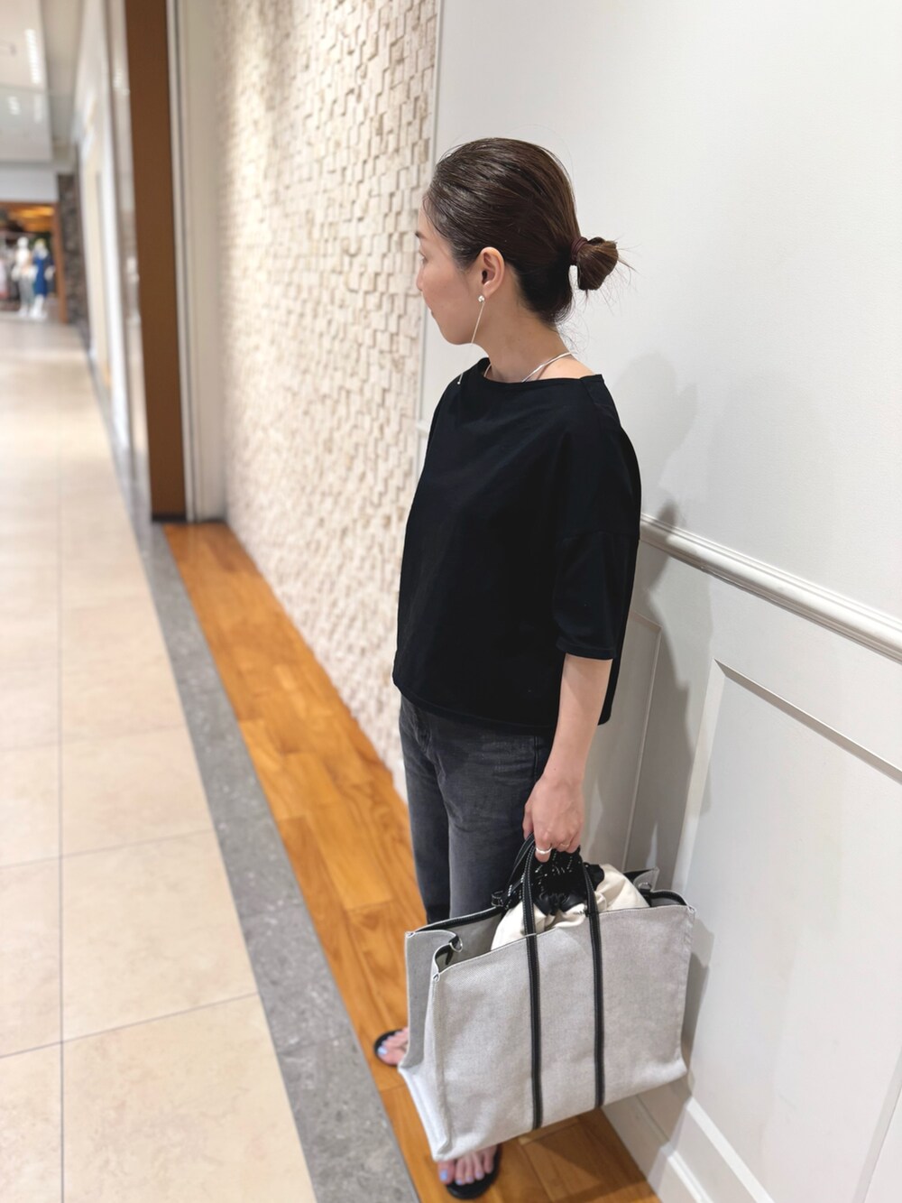 ブラック系のTシャツ/カットソー、ホワイト系のショルダーバッグ、ブラック系のデニムパンツを着用したレディースの夏コーディネートの4枚目の写真