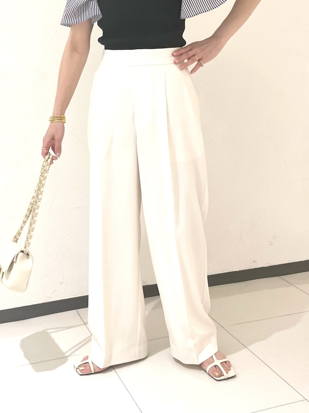 ホワイト系のその他パンツ、ホワイト系のショルダーバッグ、ブルー系のシャツ/ブラウスを着用したレディースの春コーディネートの4枚目の写真