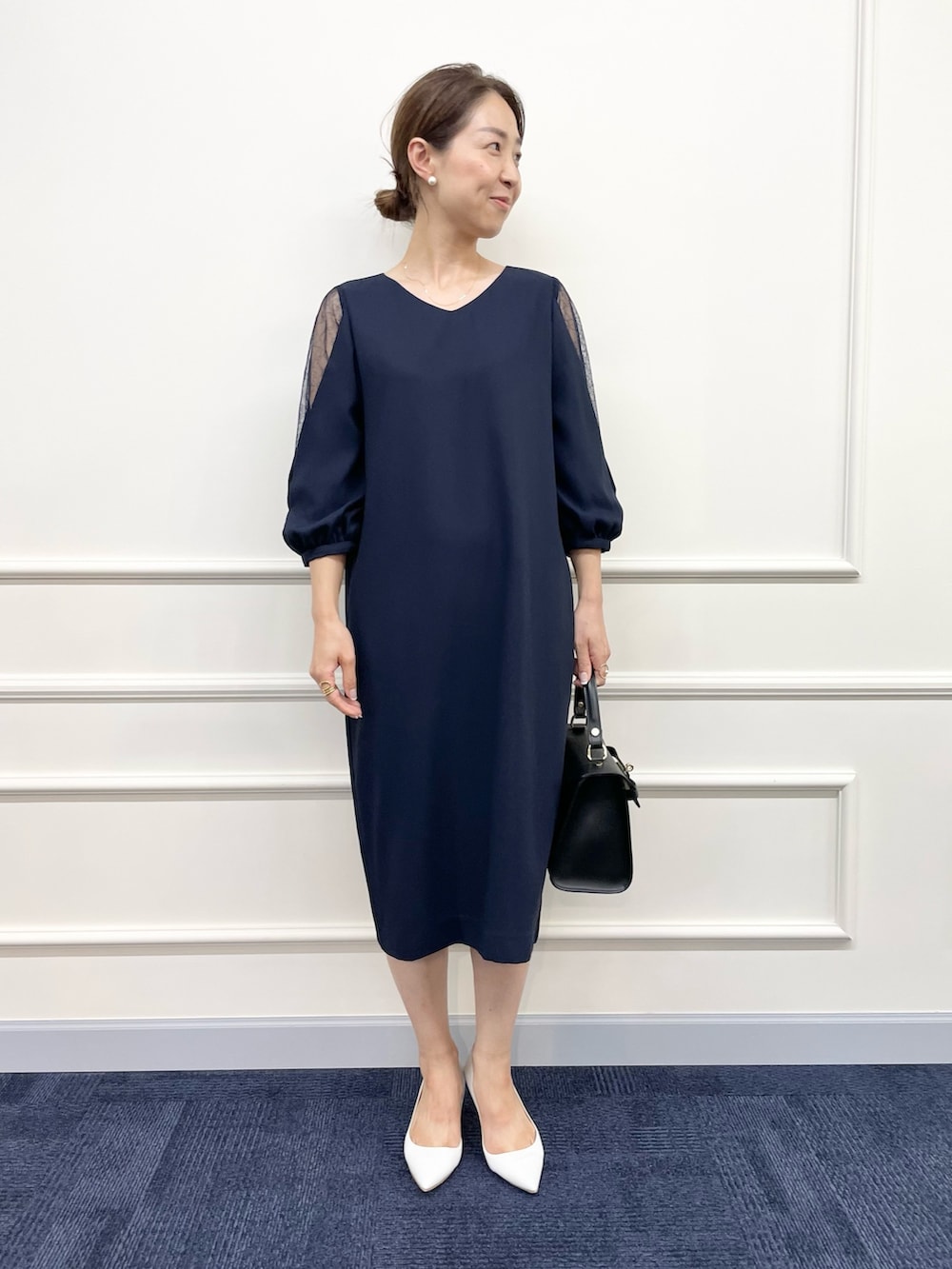 ブルー系のワンピース、ブラック系のショルダーバッグ、ホワイト系のピアス（両耳用）を着用したレディースの秋コーディネートの3枚目の写真