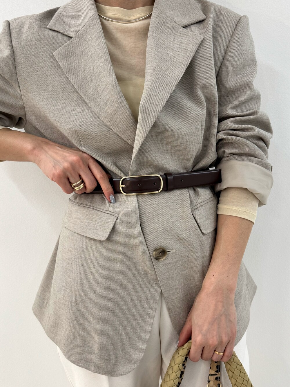 ベージュ系のショルダーバッグ、イエロー系のTシャツ/カットソー、グレー系のテーラードジャケットを着用したレディースの冬コーディネートの5枚目の写真