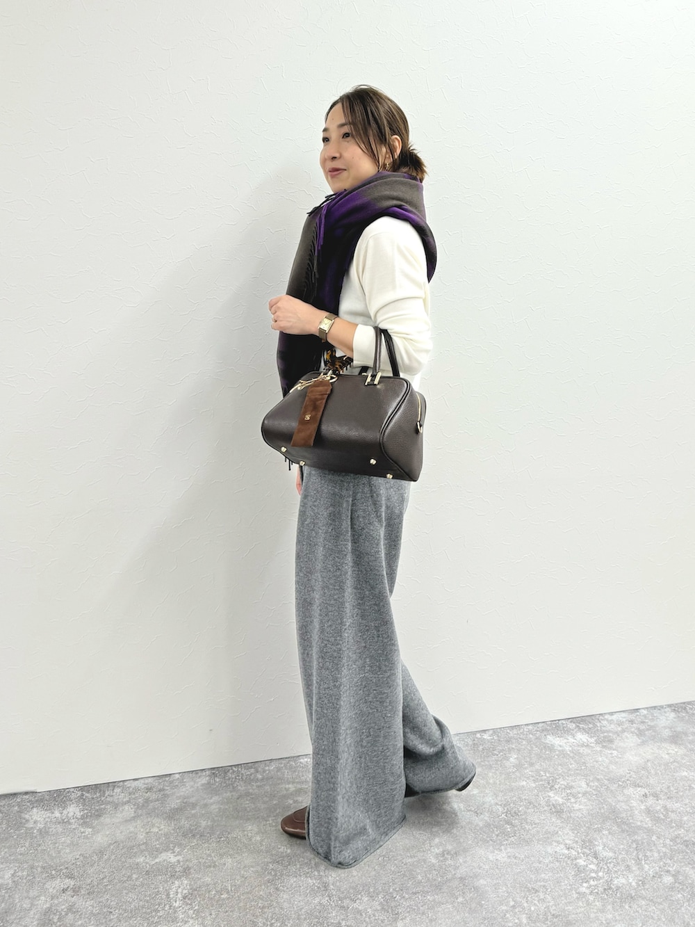 グレー系のその他パンツ、ブラウン系のショルダーバッグ、ホワイト系のニット/セーターを着用したレディースの秋コーディネートの3枚目の写真