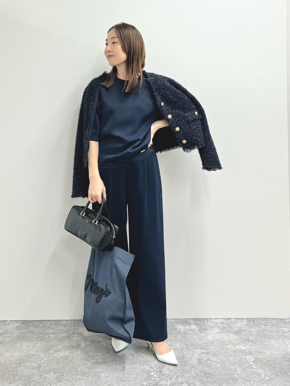 ブルー系のノーカラージャケット、ブルー系のシャツ/ブラウス、ブラック系のバッグを着用したレディースの秋コーディネートの2枚目の写真
