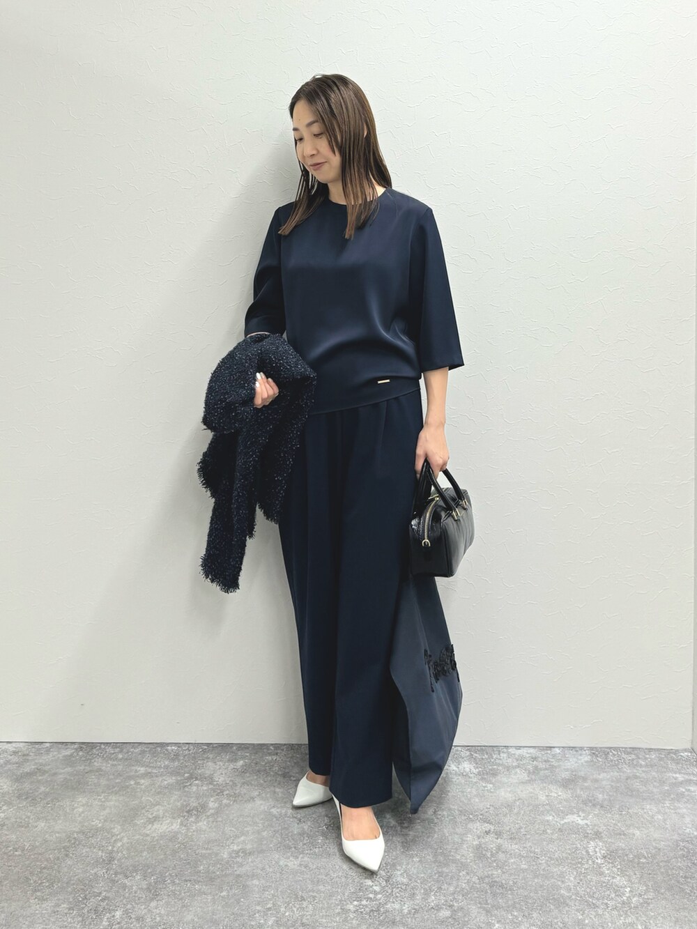 ブルー系のノーカラージャケット、ブルー系のシャツ/ブラウス、ブラック系のバッグを着用したレディースの秋コーディネートの6枚目の写真