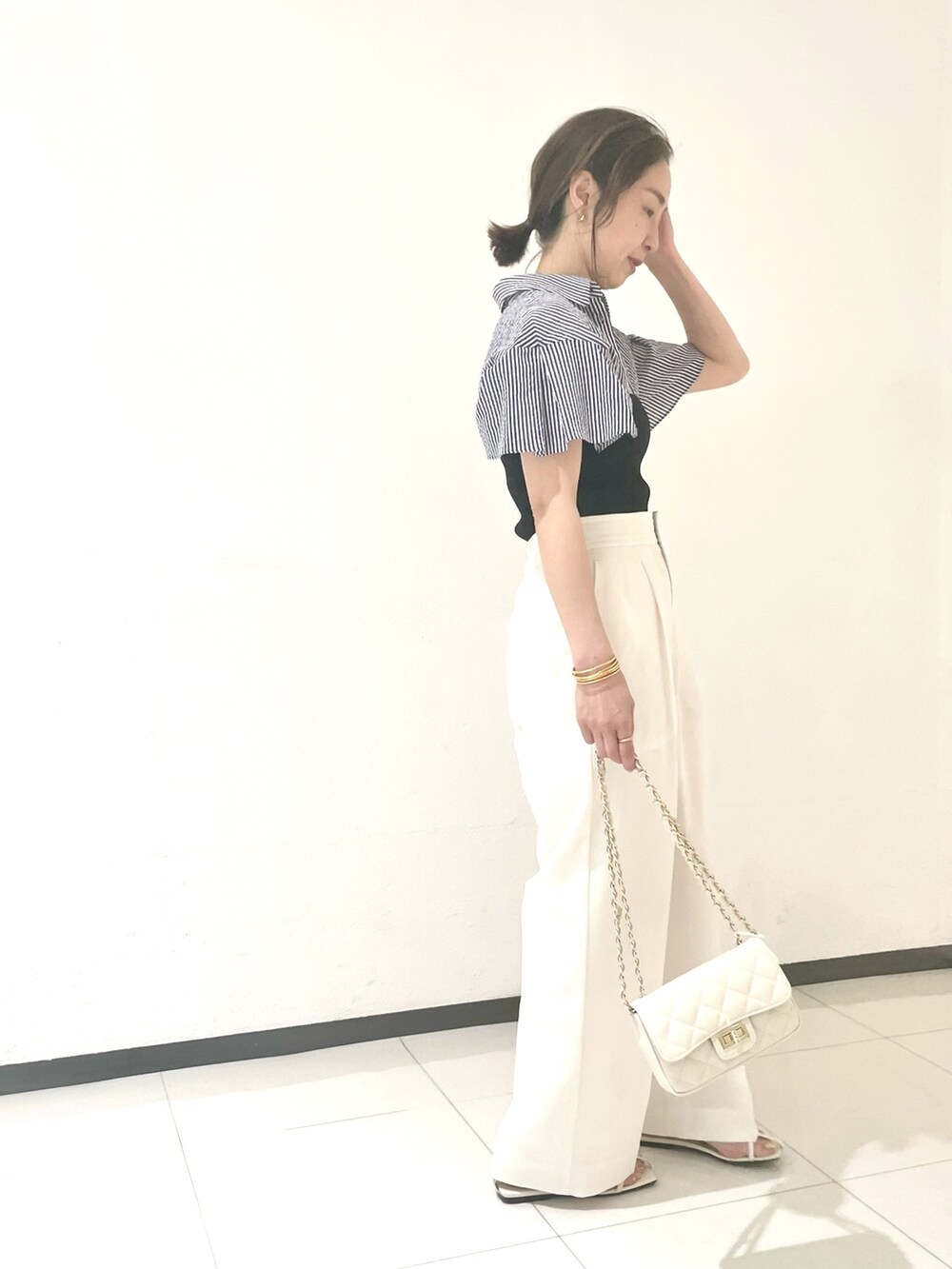 ホワイト系のその他パンツ、ホワイト系のショルダーバッグ、ブルー系のシャツ/ブラウスを着用したレディースの春コーディネートの2枚目の写真