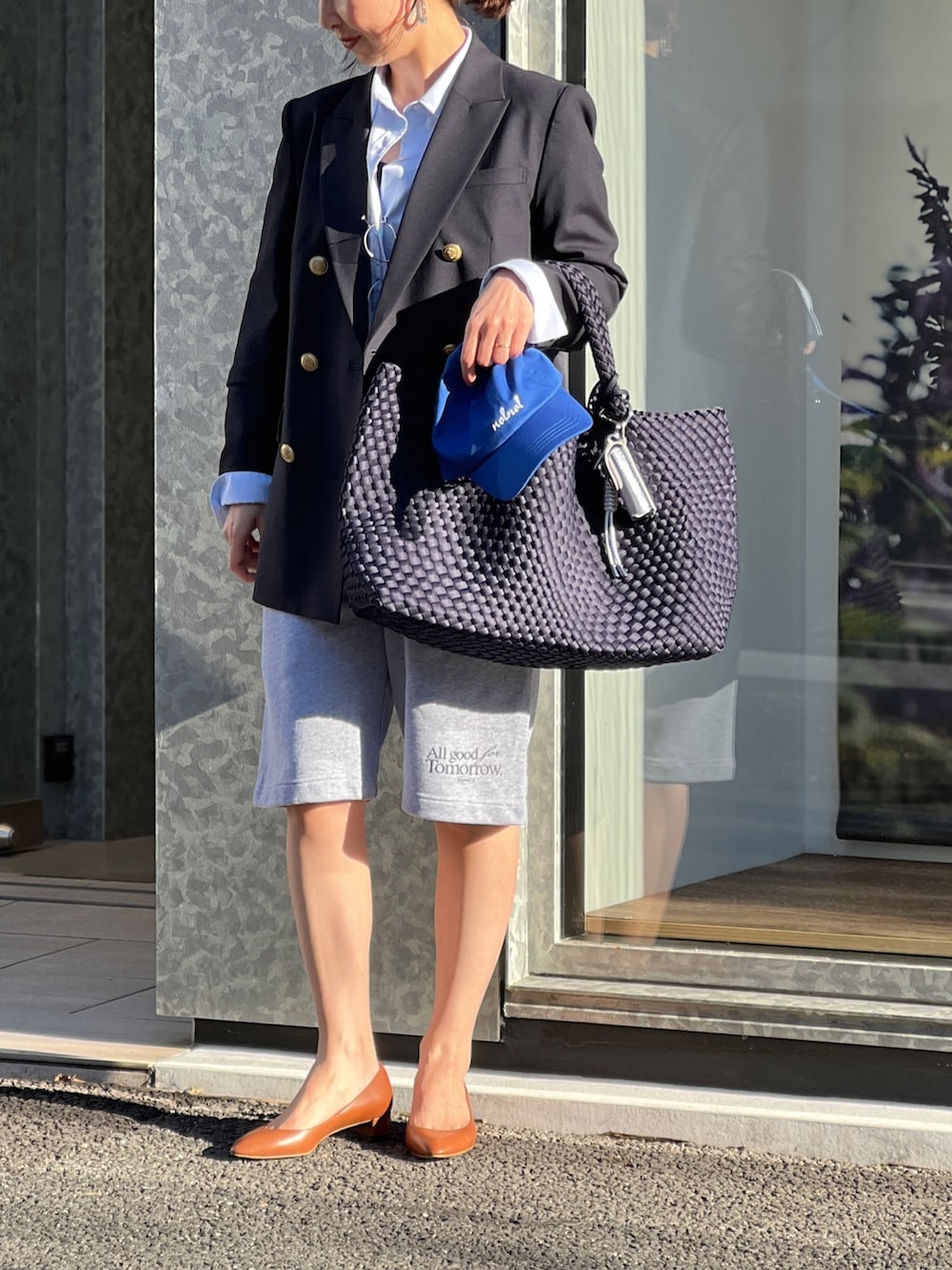 ブルー系のテーラードジャケット、ブルー系のトートバッグ、グレー系のスウェットパンツを着用したレディースの春コーディネートの8枚目の写真