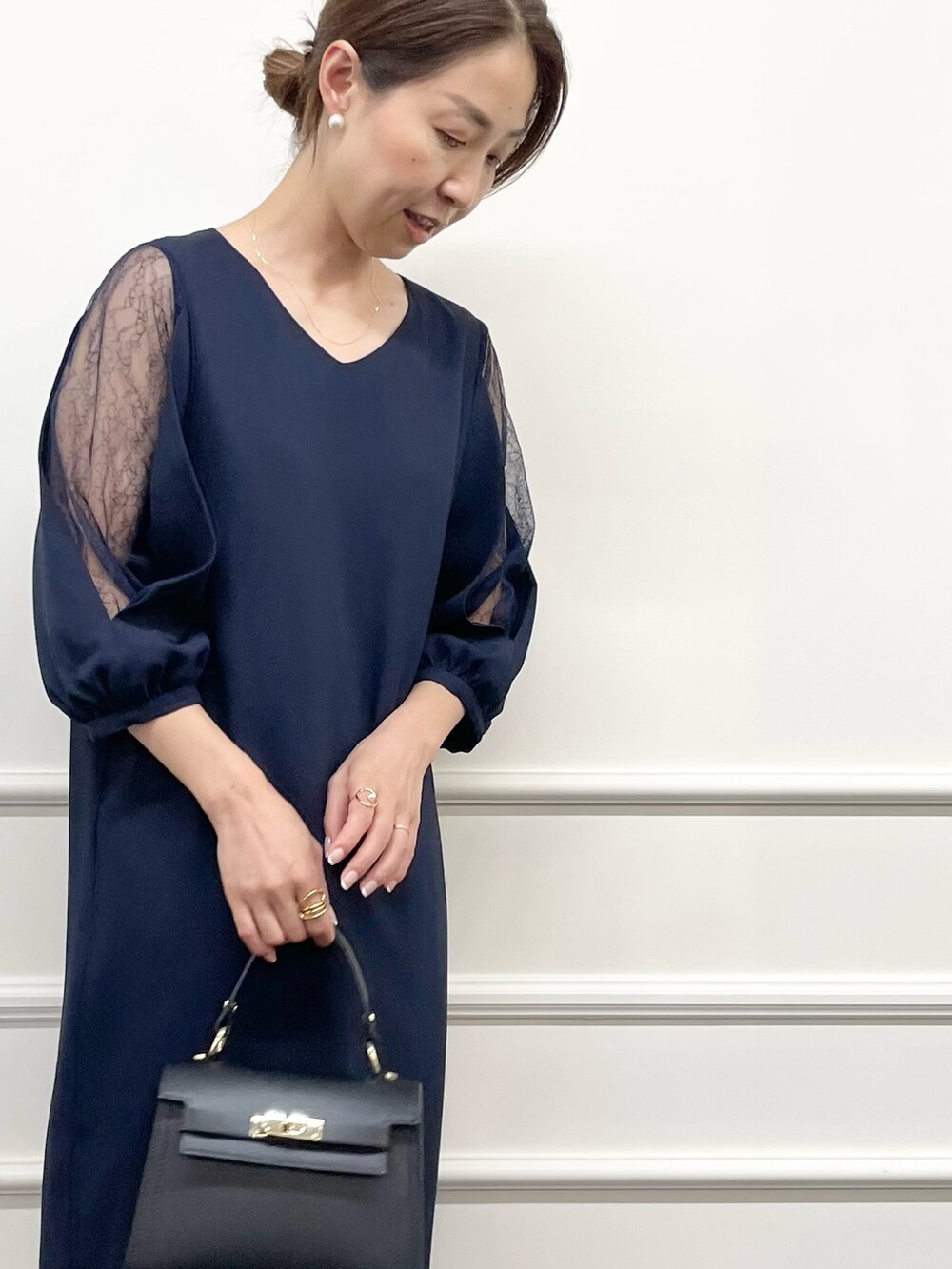 ブルー系のワンピース、ブラック系のショルダーバッグ、ホワイト系のピアス（両耳用）を着用したレディースの秋コーディネートの7枚目の写真