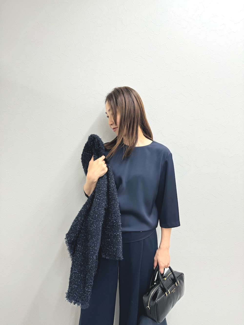 ブルー系のノーカラージャケット、ブルー系のシャツ/ブラウス、ブラック系のバッグを着用したレディースの秋コーディネートの5枚目の写真