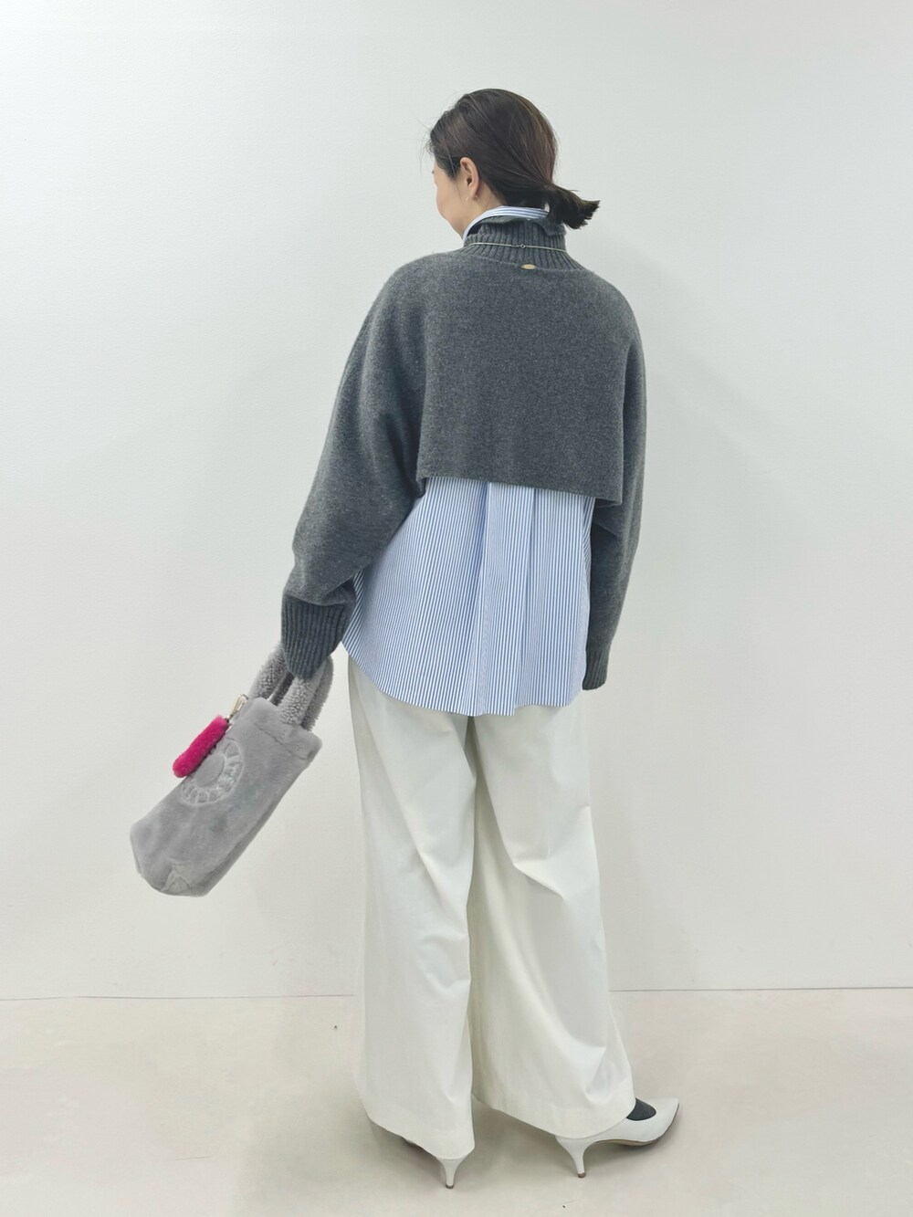 グレー系のニット/セーター、ブルー系のシャツ/ブラウス、ホワイト系のその他パンツを着用したレディースの秋コーディネートの6枚目の写真