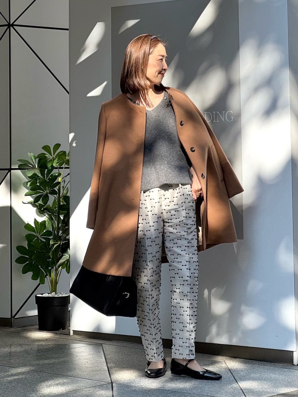 ベージュ系のその他パンツ、ブラック系のパンプス、イエロー系のノーカラーコートを着用したレディースの冬コーディネートの3枚目の写真