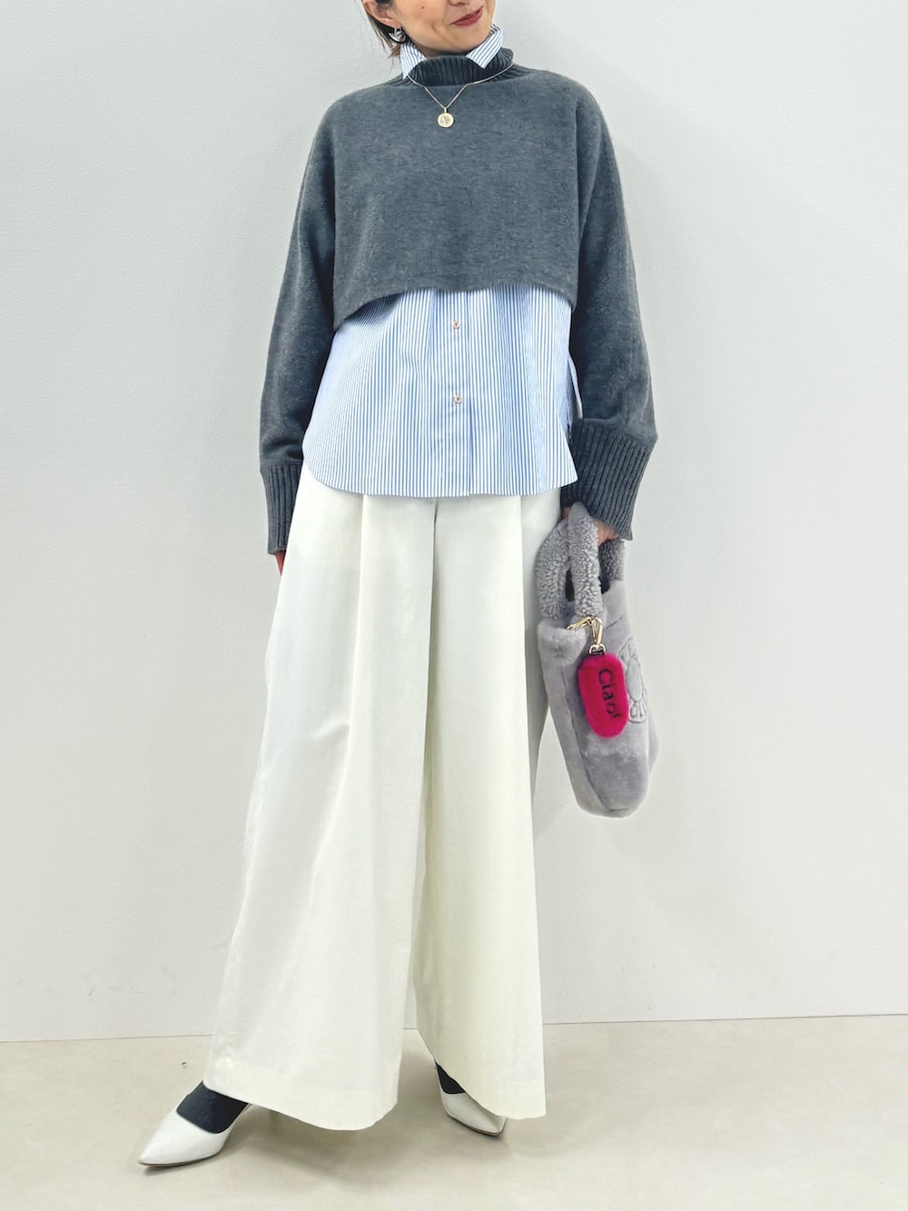 グレー系のニット/セーター、ブルー系のシャツ/ブラウス、ホワイト系のその他パンツを着用したレディースの秋コーディネートの8枚目の写真