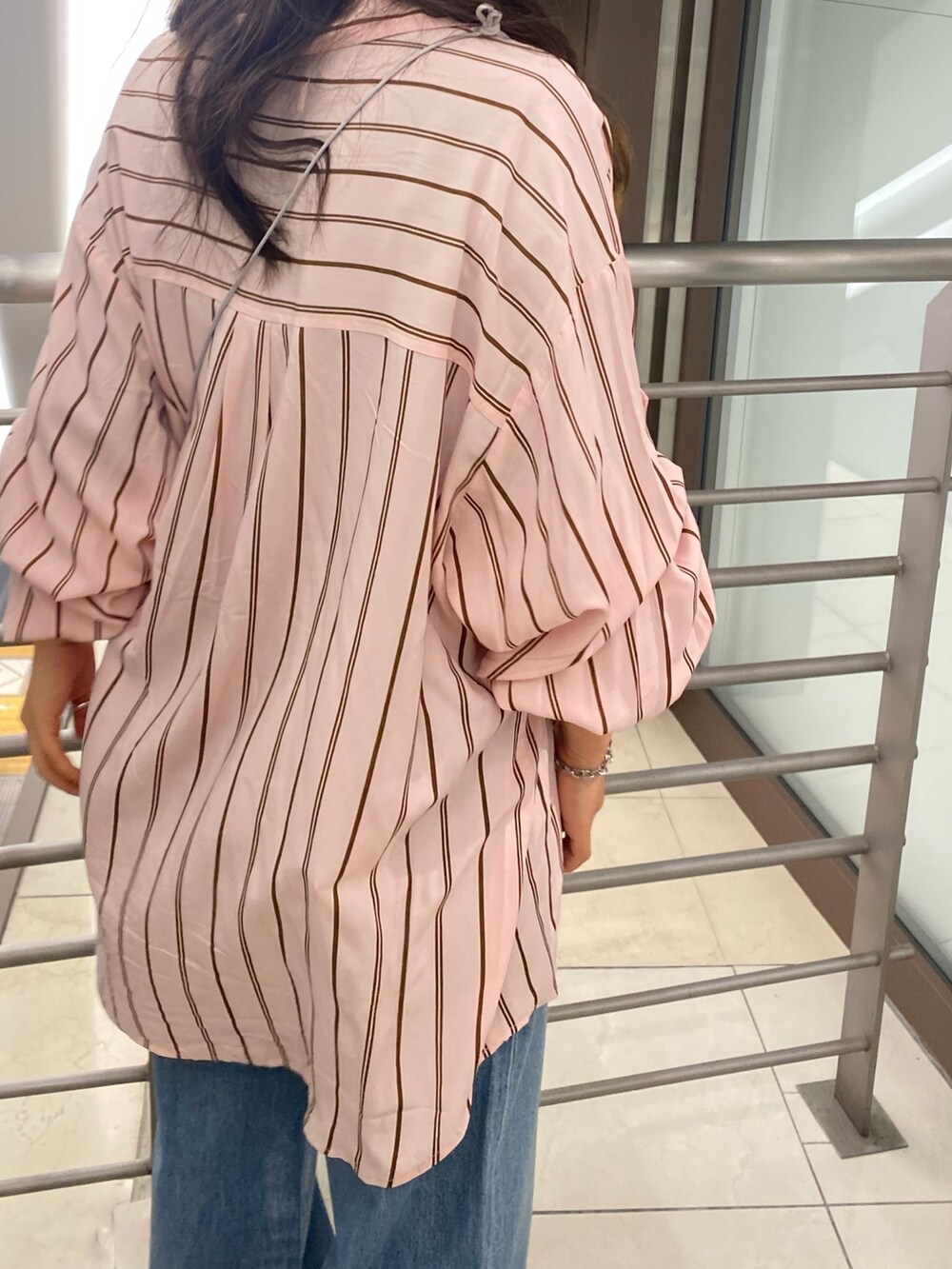 ピンク系のシャツ/ブラウス、ブルー系のデニムパンツ、シルバー系のショルダーバッグを着用したレディースの冬コーディネートの7枚目の写真