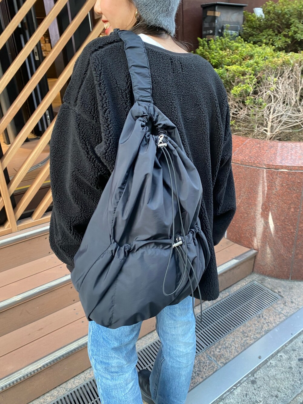 ブラック系のTシャツ/カットソー、ブラック系のハンドバッグ、ブラック系のブーツを着用したレディースの秋コーディネートの7枚目の写真