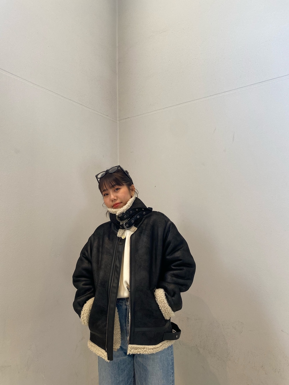 ブラック系のムートンコート、ブルー系のデニムパンツを着用したレディースの冬コーディネートの6枚目の写真