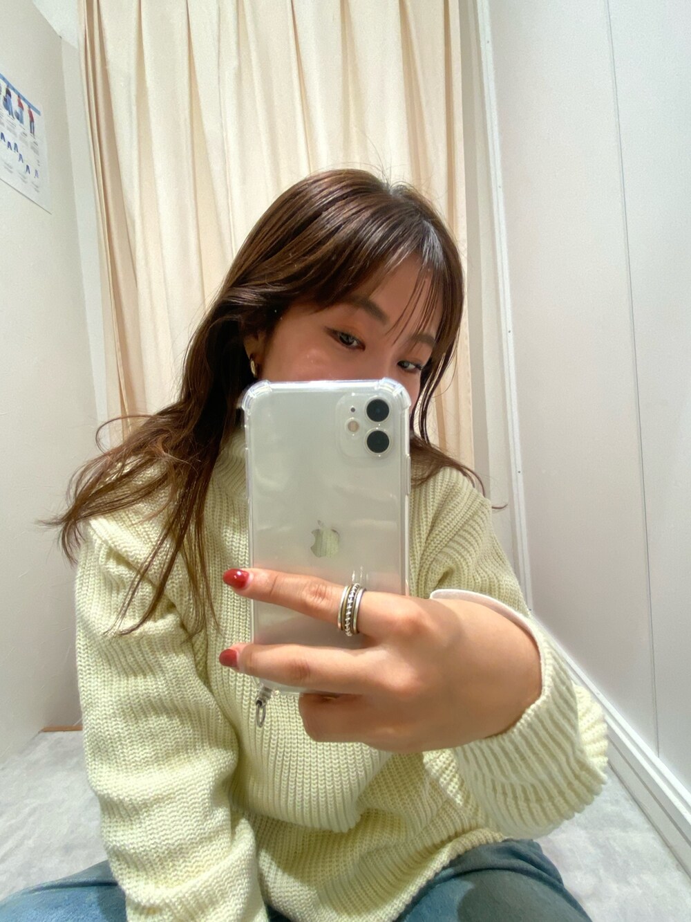 ホワイト系のニット/セーター、ブルー系のデニムパンツ、ホワイト系のTシャツ/カットソーを着用したレディースの冬コーディネートの3枚目の写真