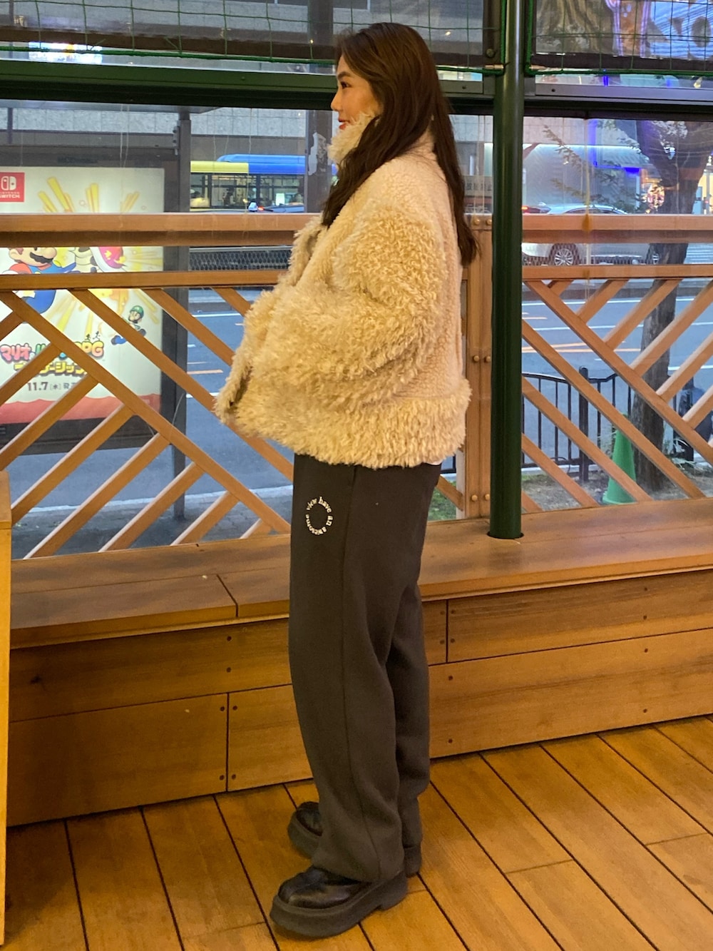 ホワイト系のムートンコート、グレー系のスウェットパンツを着用したレディースの冬コーディネートの2枚目の写真