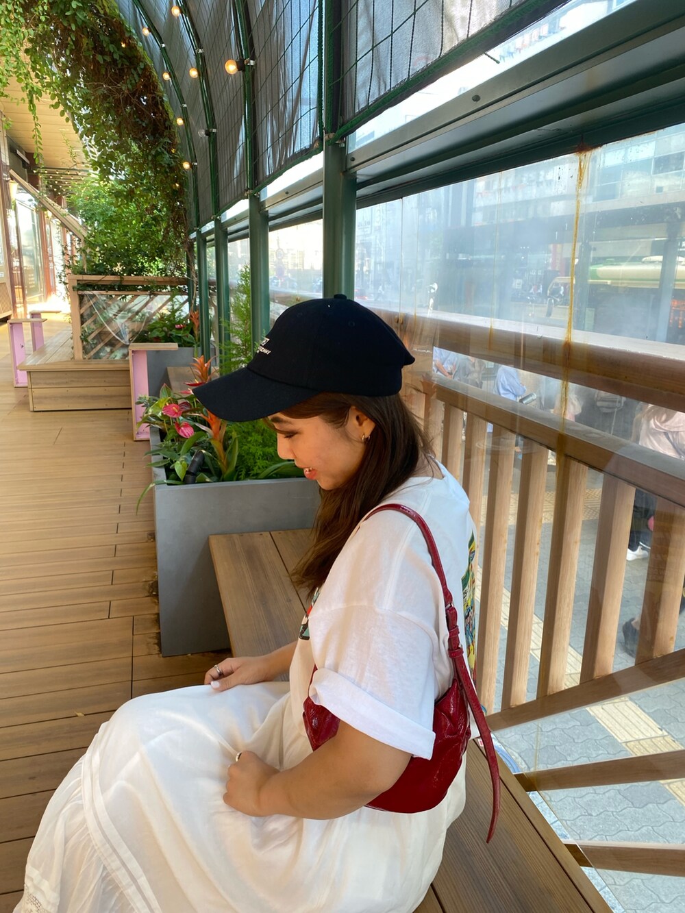 ホワイト系のTシャツ/カットソー、ホワイト系のスカート、ブラック系のキャップを着用したレディースの夏コーディネートの5枚目の写真