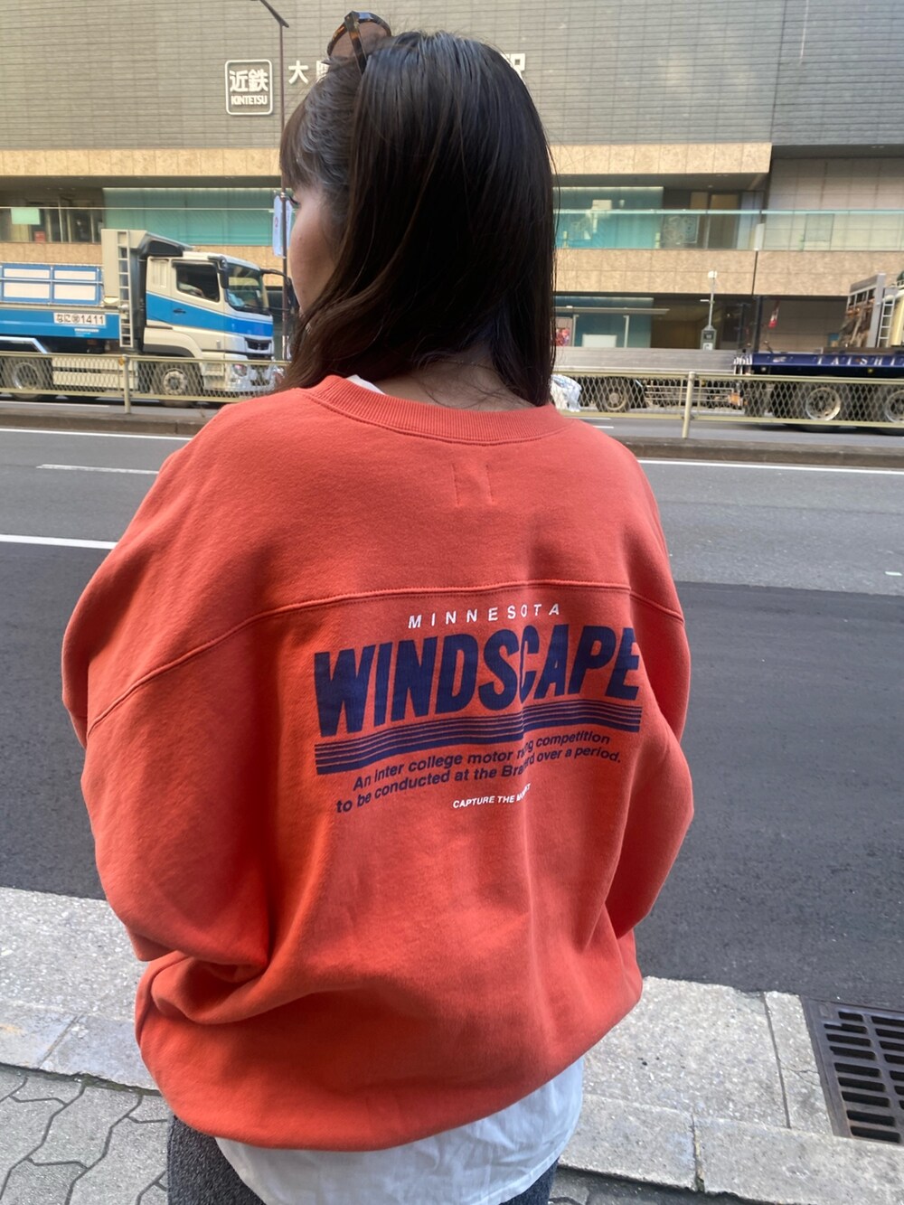 オレンジ系のスウェット、ホワイト系のTシャツ/カットソー、グレー系のスカートを着用したレディースの冬コーディネートの5枚目の写真