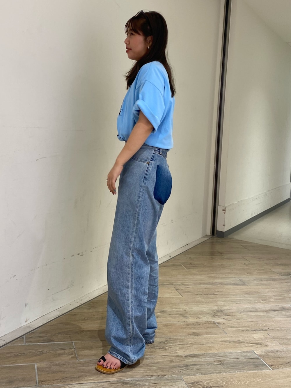 ブルー系のTシャツ/カットソー、ブルー系のデニムパンツ、ブラック系のサンダルを着用したレディースの春コーディネートの2枚目の写真