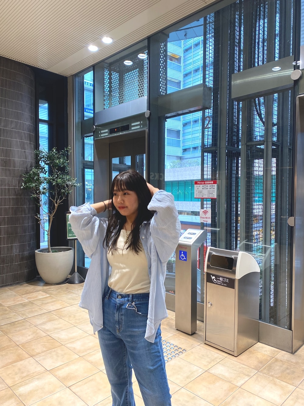 ブルー系のシャツ/ブラウス、ブルー系のデニムパンツ、ホワイト系のキャミソールを着用したレディースの春コーディネートの6枚目の写真