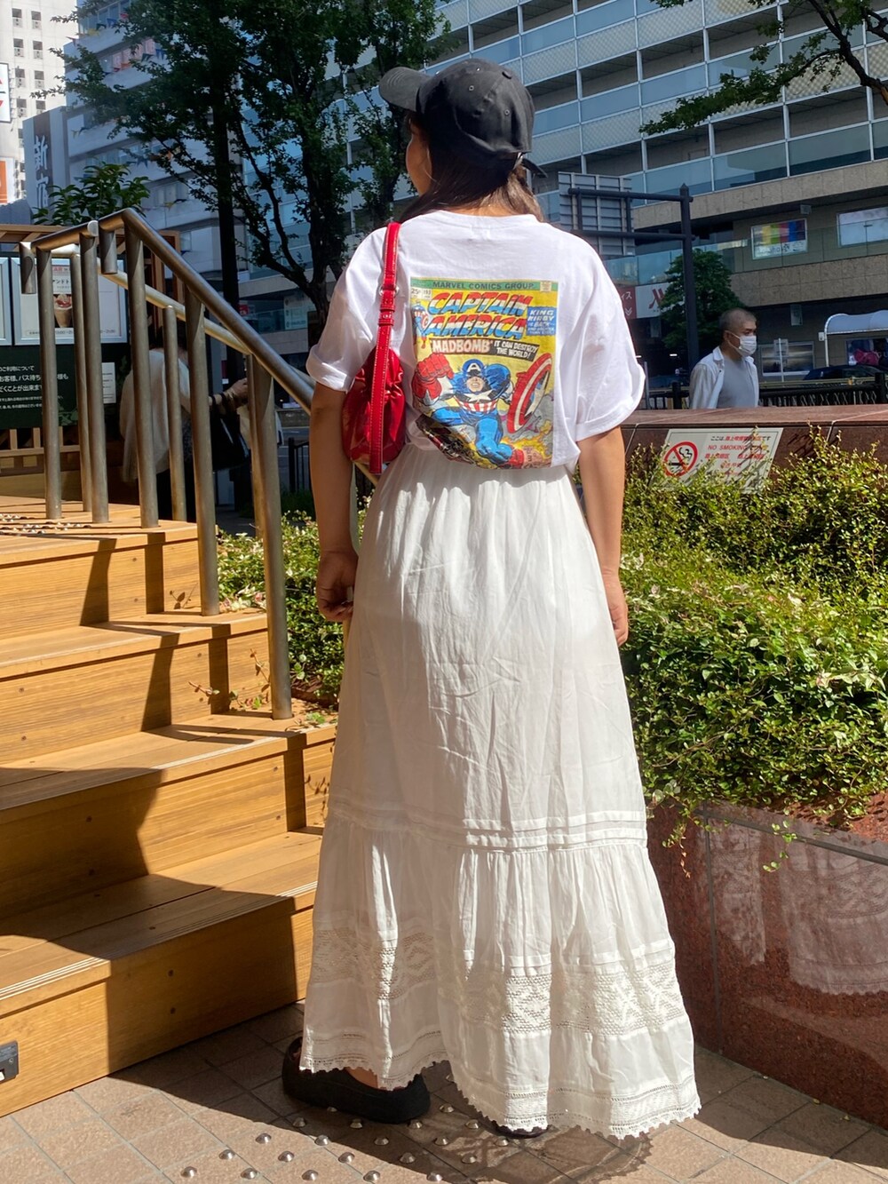 ホワイト系のTシャツ/カットソー、ホワイト系のスカート、ブラック系のキャップを着用したレディースの夏コーディネートの3枚目の写真