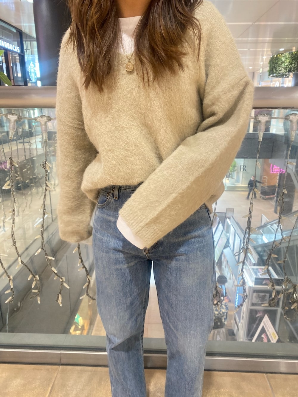 グレー系のニット/セーター、ブルー系のデニムパンツを着用したレディースの冬コーディネートの7枚目の写真