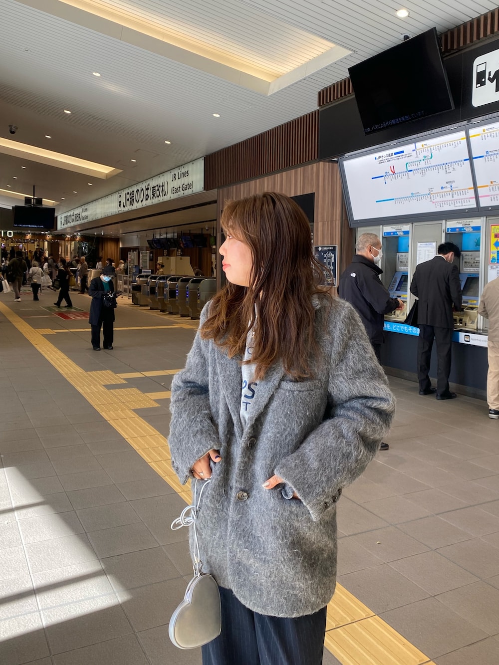 グレー系のテーラードジャケット、グレー系のニット/セーター、シルバー系のショルダーバッグを着用したレディースの冬コーディネートの4枚目の写真