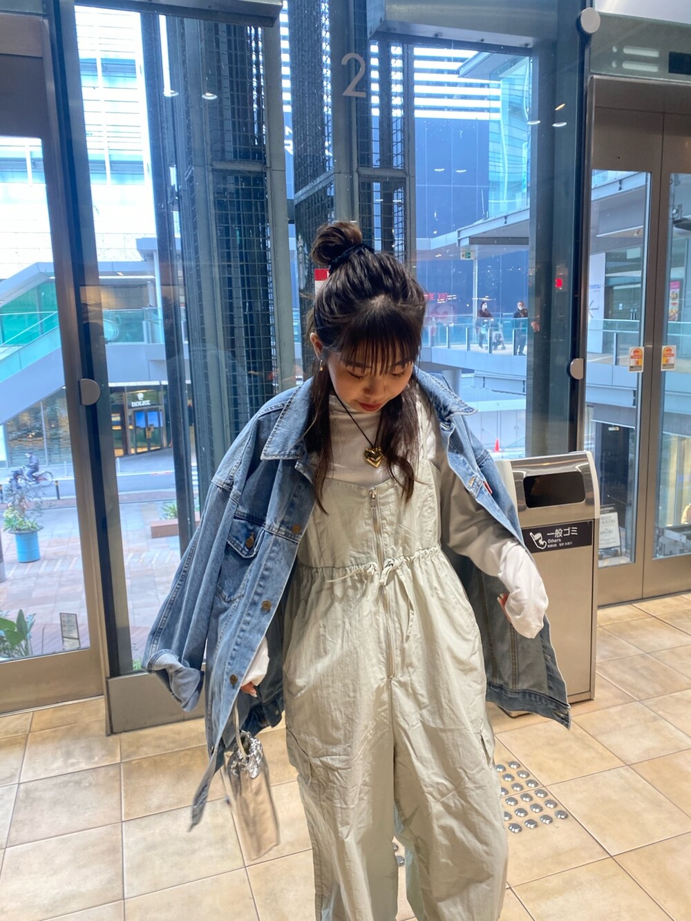 ブルー系のデニムジャケット、グレー系のサロペット/オーバーオール、ゴールド系のネックレスを着用したレディースの冬コーディネートの5枚目の写真