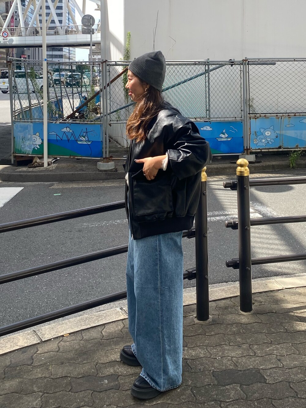 ホワイト系のニット/セーター、ブルー系のデニムパンツ、ブラック系のブルゾンを着用したレディースの秋コーディネートの2枚目の写真