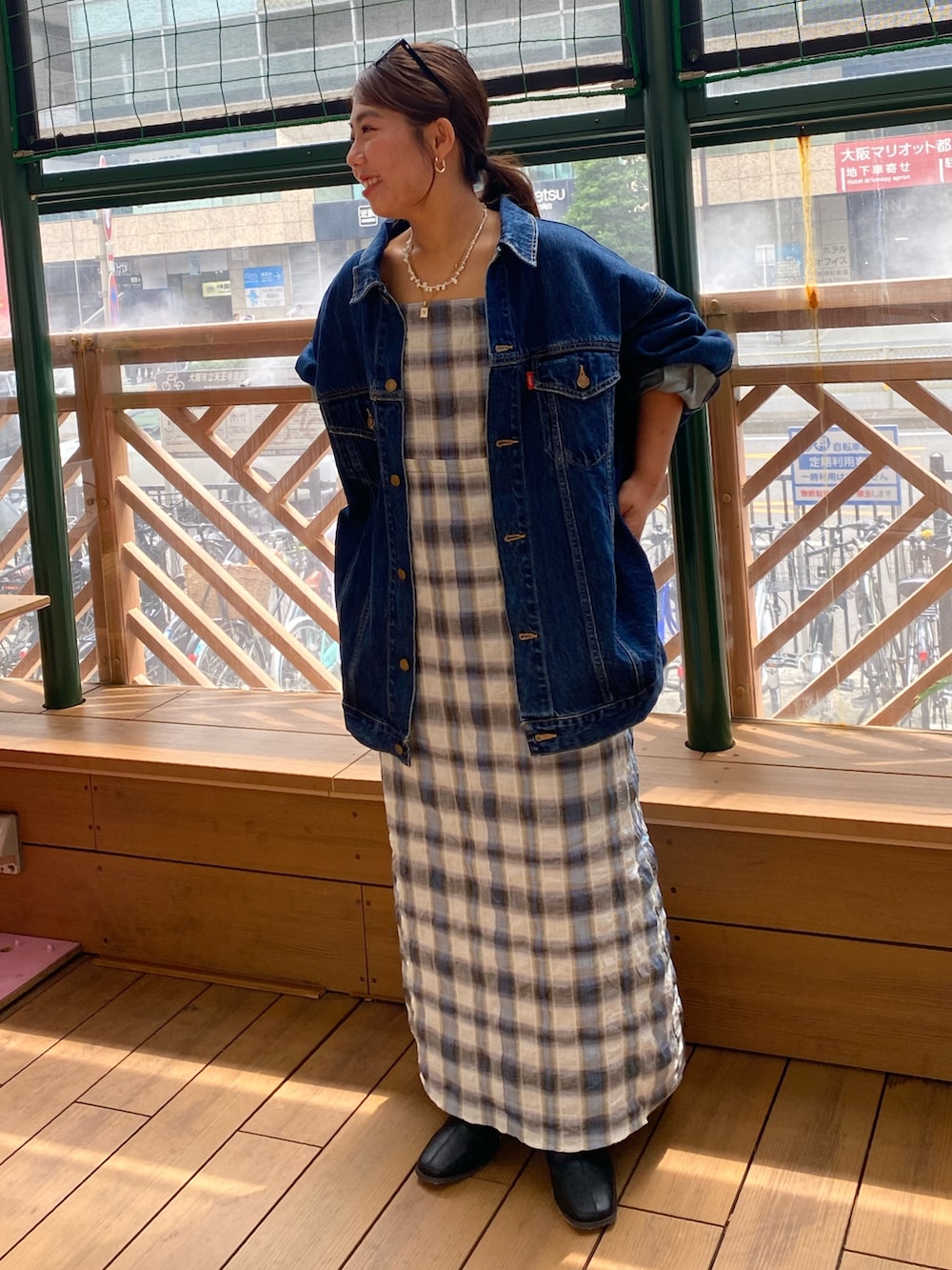 ブルー系のデニムジャケット、ブルー系のワンピースを着用したレディースの秋コーディネートの4枚目の写真