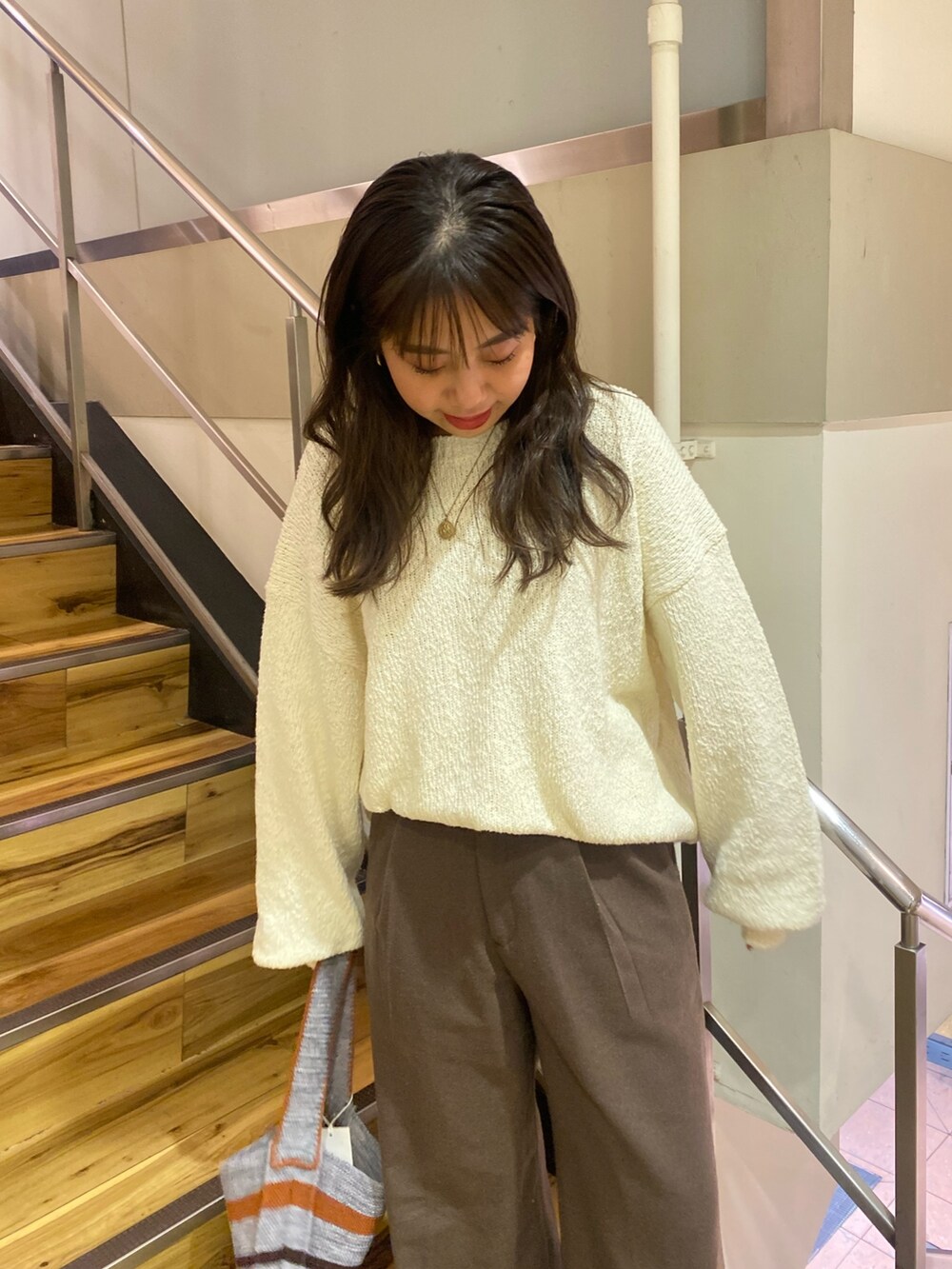 ホワイト系のニット/セーター、ブラウン系のその他パンツ、グレー系のハンドバッグを着用したレディースの冬コーディネートの4枚目の写真