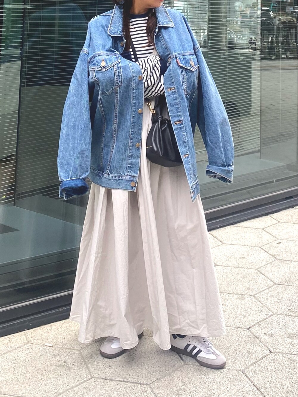 ブルー系のデニムジャケット、グレー系のワンピース、ブルー系のTシャツ/カットソーを着用したレディースの冬コーディネートの7枚目の写真