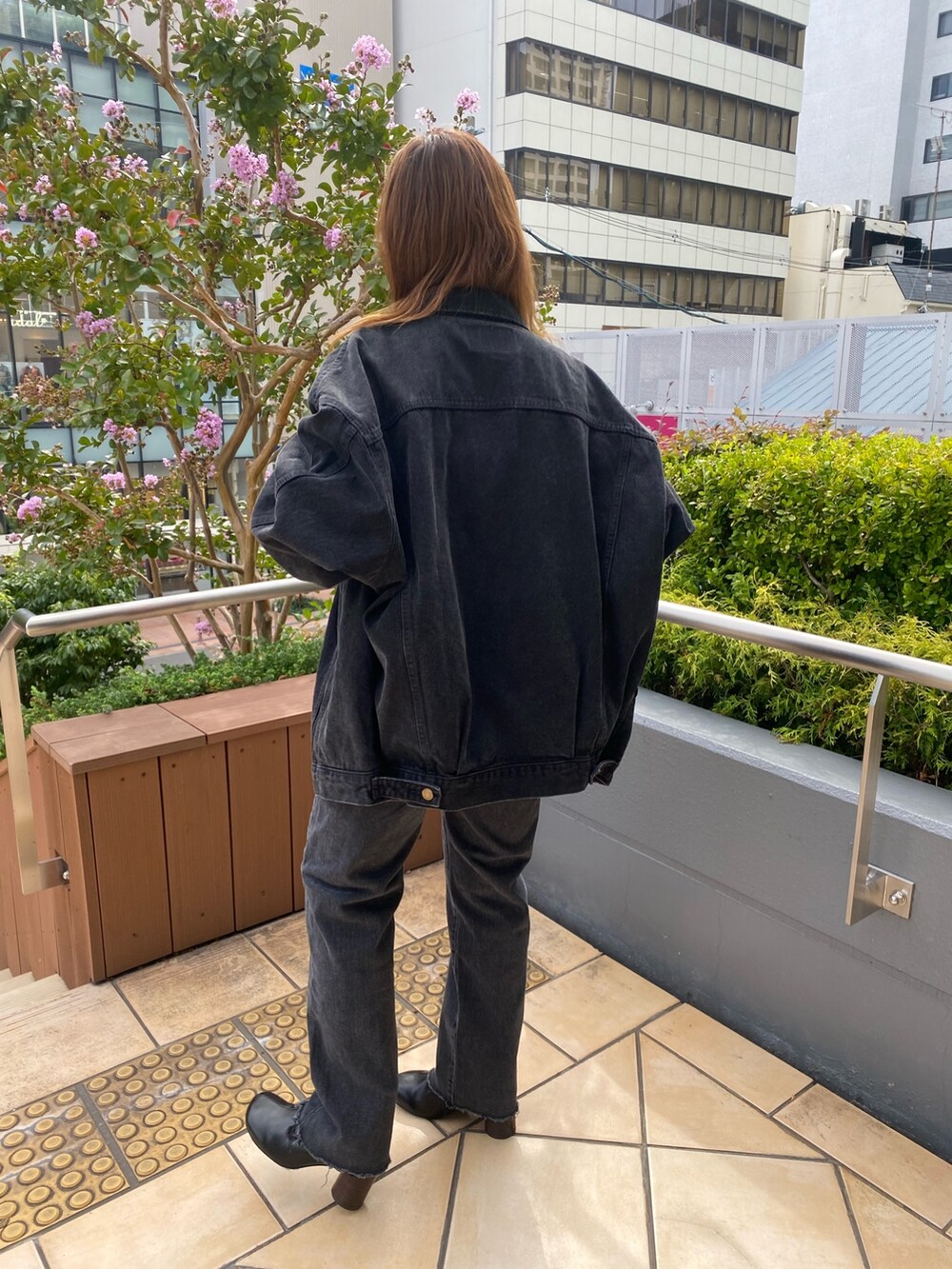 ブラック系のデニムジャケット、ブラック系のデニムパンツ、ピンク系のニット/セーターを着用したレディースの秋コーディネートの3枚目の写真