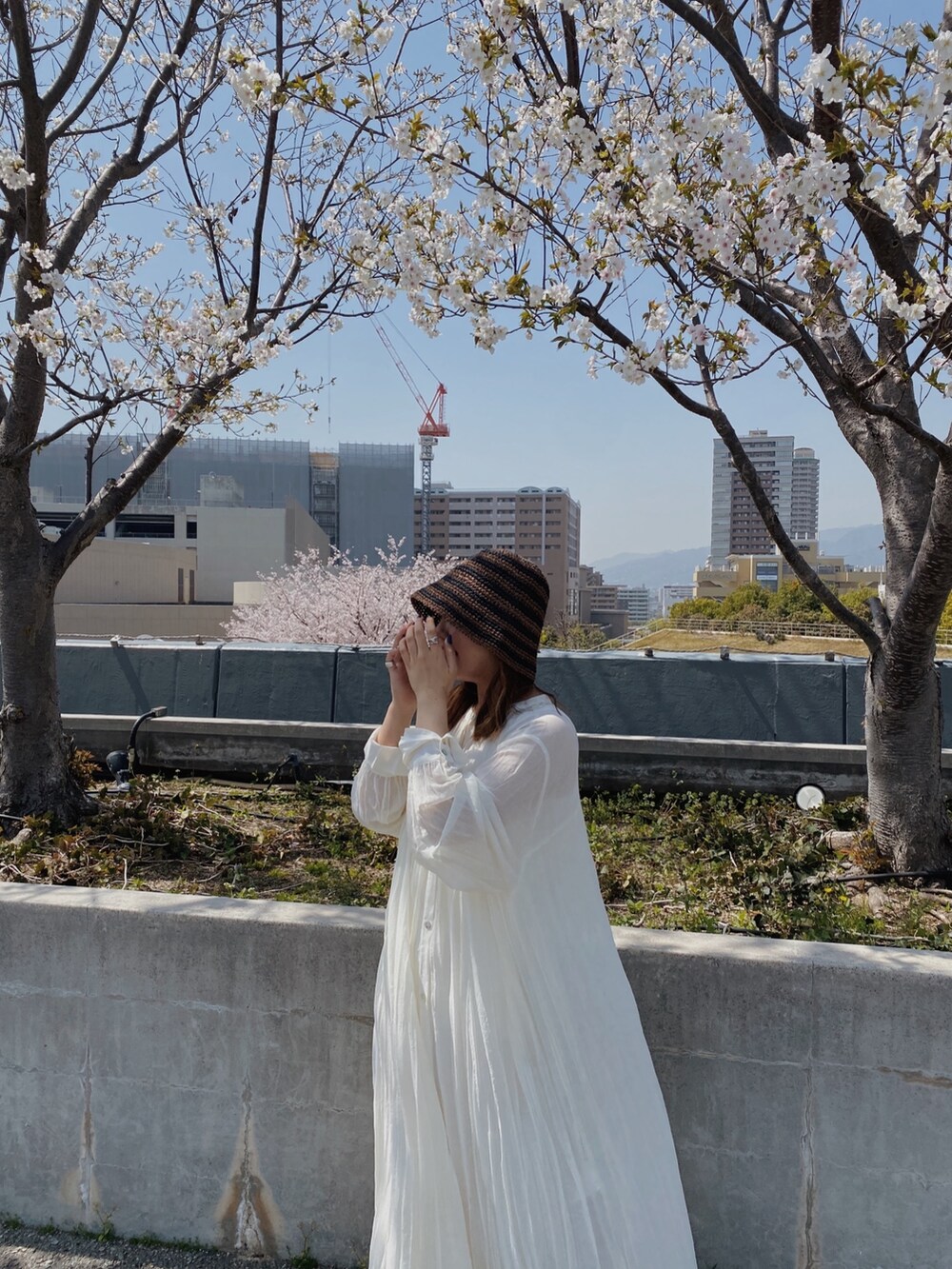 ホワイト系のワンピース、ブラウン系のハットを着用したレディースの春コーディネートの3枚目の写真