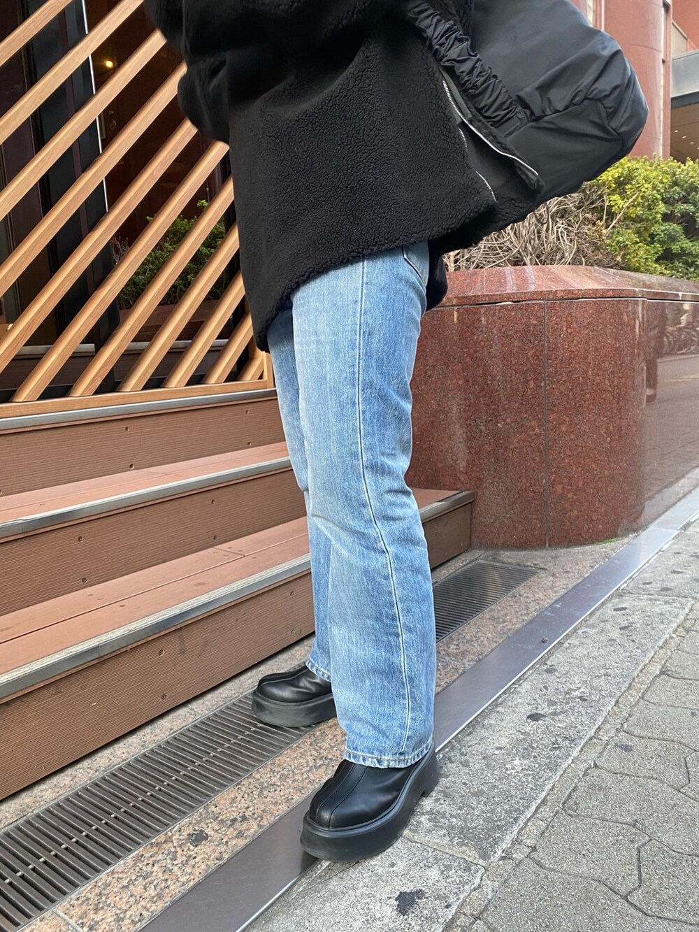 ブラック系のTシャツ/カットソー、ブラック系のハンドバッグ、ブラック系のブーツを着用したレディースの秋コーディネートの6枚目の写真