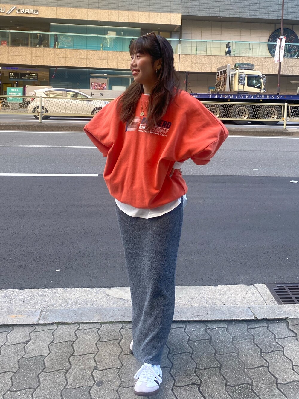 オレンジ系のスウェット、ホワイト系のTシャツ/カットソー、グレー系のスカートを着用したレディースの冬コーディネートの3枚目の写真