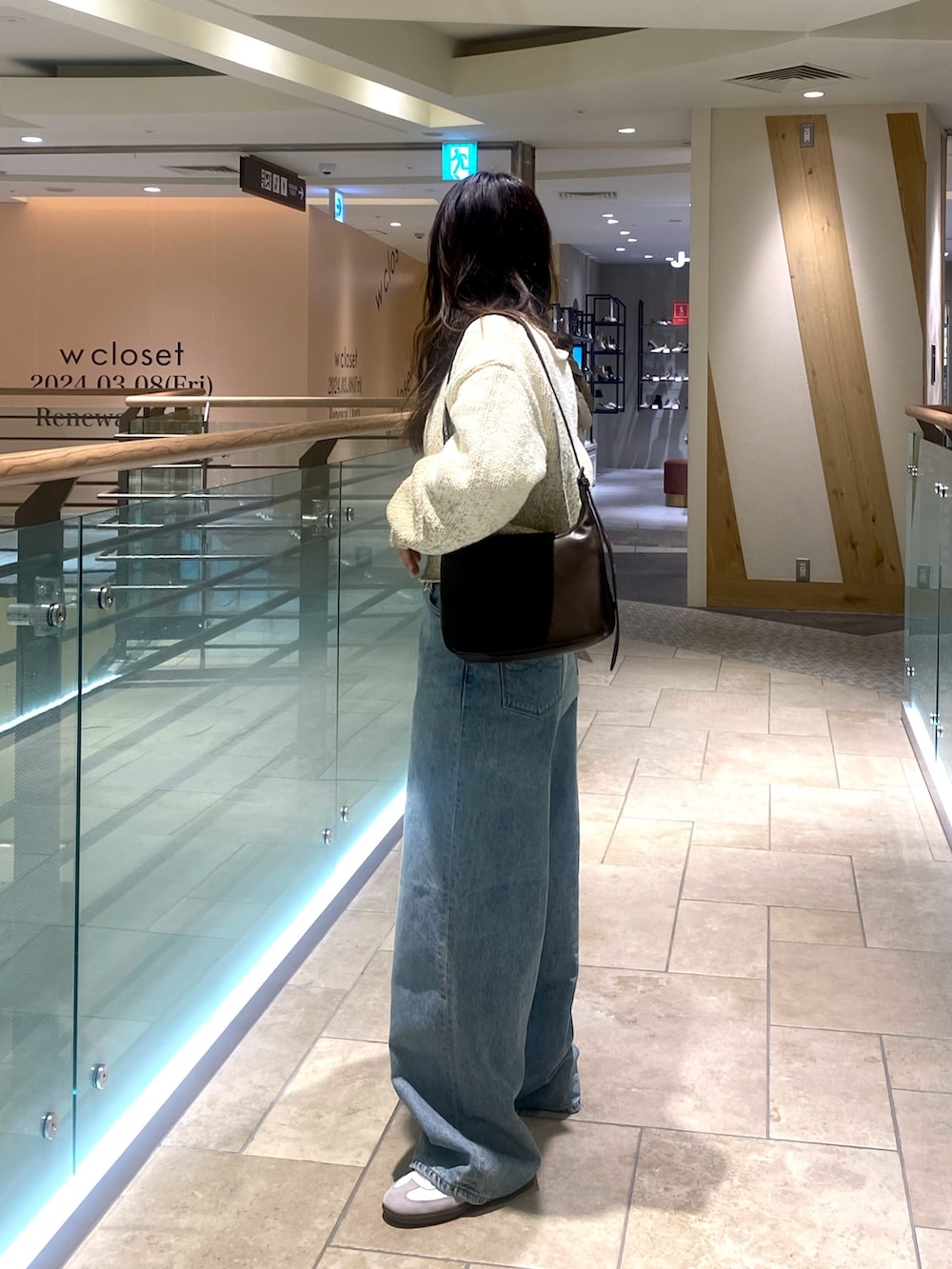 ホワイト系のニット/セーター、ブルー系のデニムパンツ、ブラウン系のショルダーバッグを着用したレディースの冬コーディネートの3枚目の写真