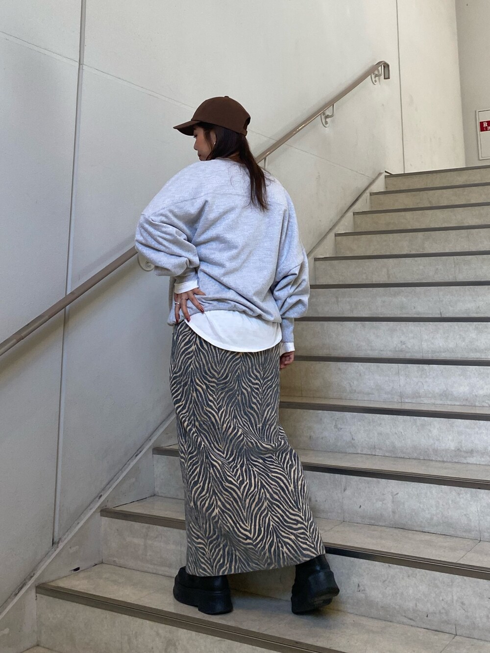 グレー系のスウェット、ブルー系のスカート、ホワイト系のTシャツ/カットソーを着用したレディースの冬コーディネートの4枚目の写真