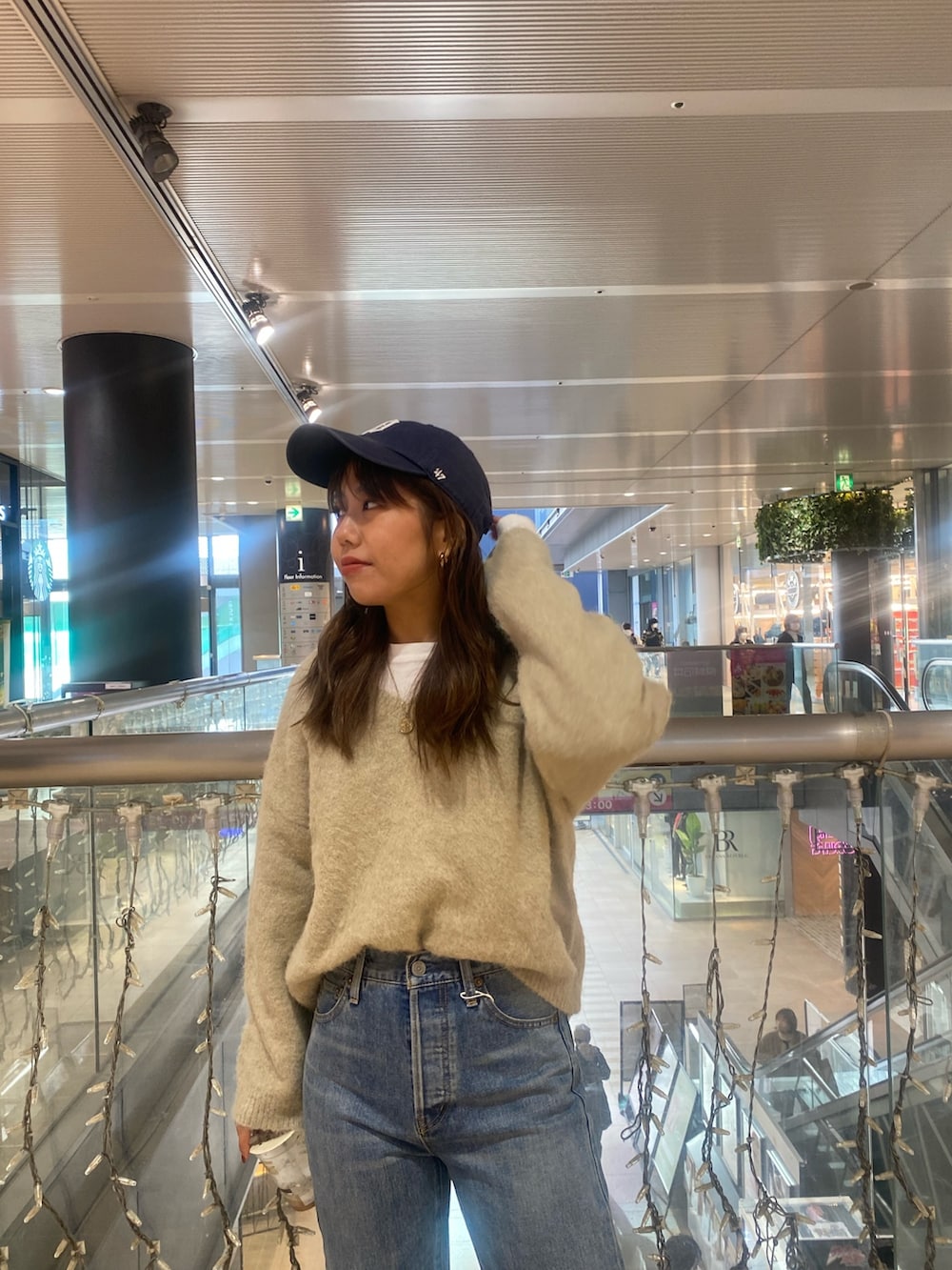 グレー系のニット/セーター、ブルー系のデニムパンツを着用したレディースの冬コーディネートの4枚目の写真