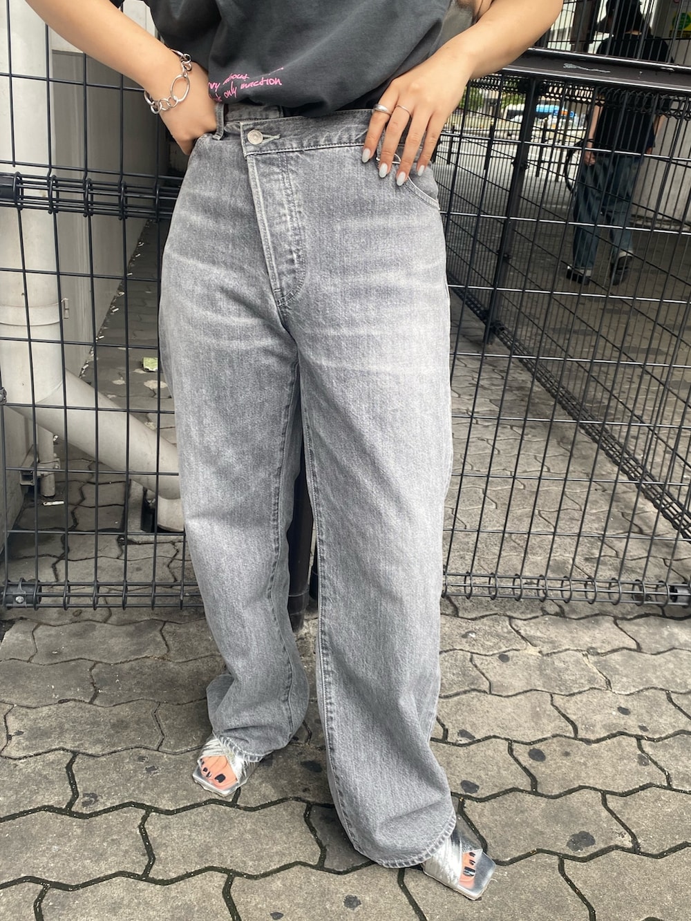 グレー系のTシャツ/カットソー、ブラック系のデニムパンツ、シルバー系のサンダルを着用したレディースの春コーディネートの7枚目の写真