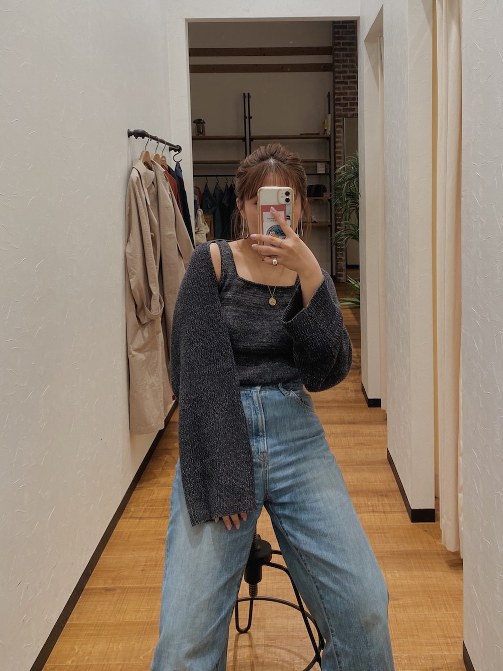 グレー系のニット/セーター、ブルー系のデニムパンツを着用したレディースの春コーディネートの2枚目の写真