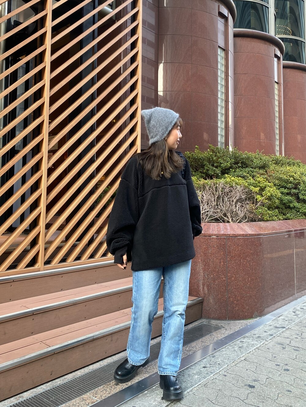 ブラック系のTシャツ/カットソー、ブラック系のハンドバッグ、ブラック系のブーツを着用したレディースの秋コーディネートの2枚目の写真