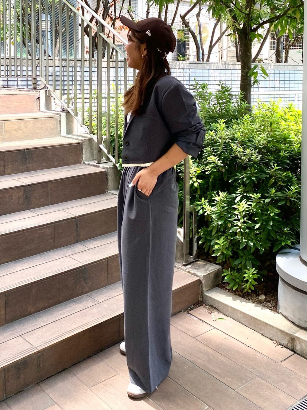 グレー系のテーラードジャケット、グレー系のその他パンツ、ブラウン系のキャップを着用したレディースの秋コーディネートの2枚目の写真