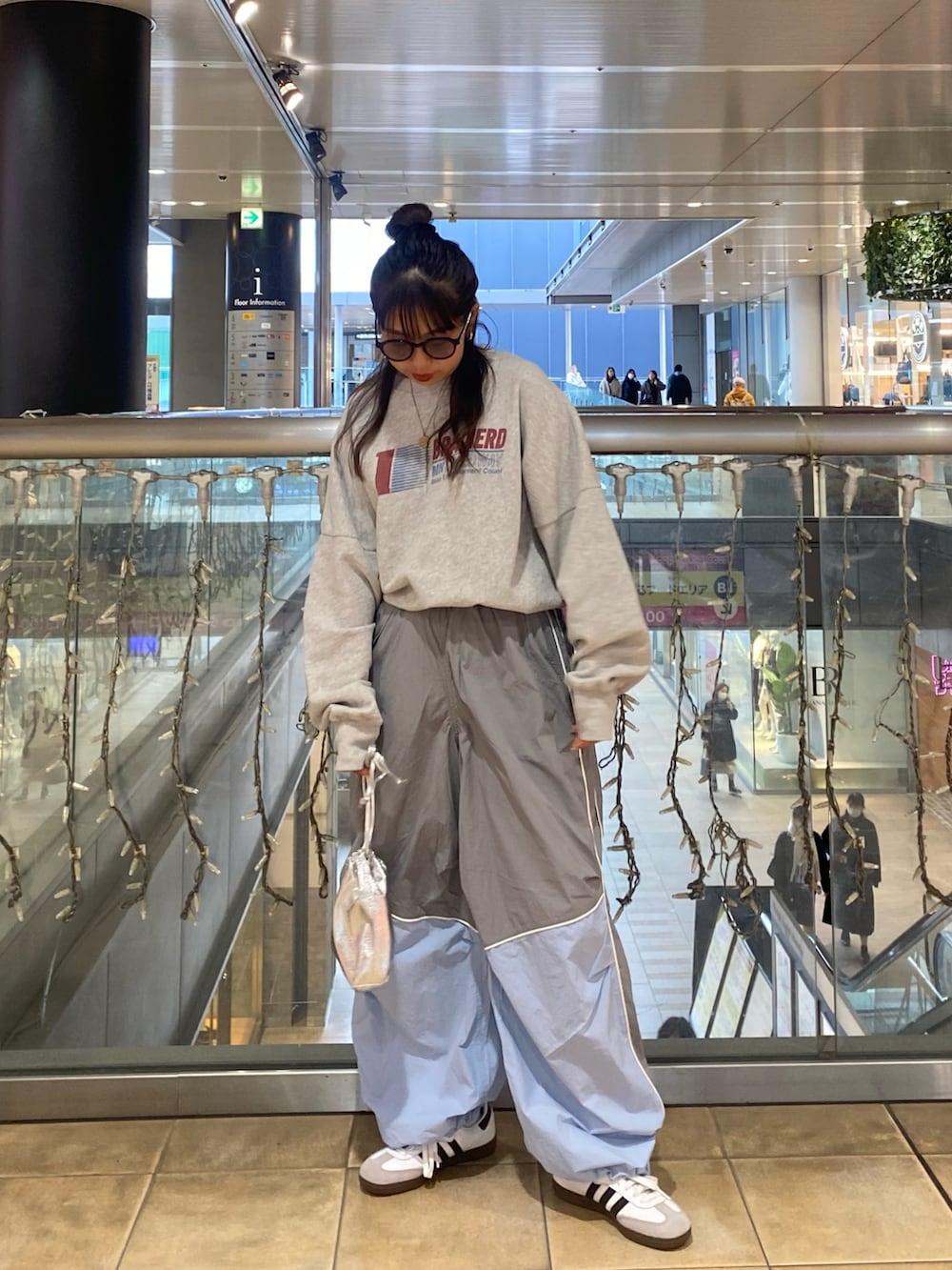 グレー系のスウェット、ブルー系のその他パンツ、ブラック系のサングラスを着用したレディースの冬コーディネートの3枚目の写真