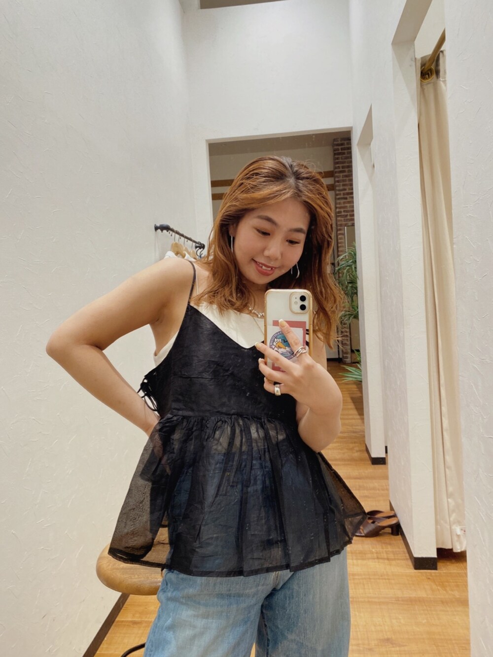 ブラック系のシャツ/ブラウス、ホワイト系のキャミソール、ブルー系のデニムパンツを着用したレディースの春コーディネートの3枚目の写真