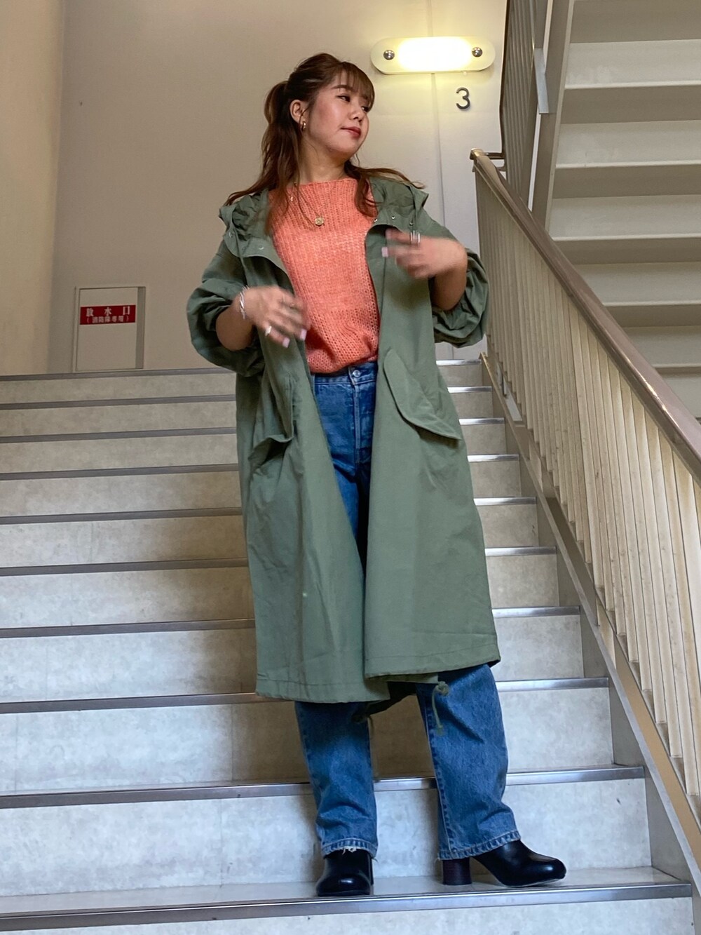 ピンク系のニット/セーター、グリーン系のブルゾン、ブルー系のデニムパンツを着用したレディースの秋コーディネートの2枚目の写真