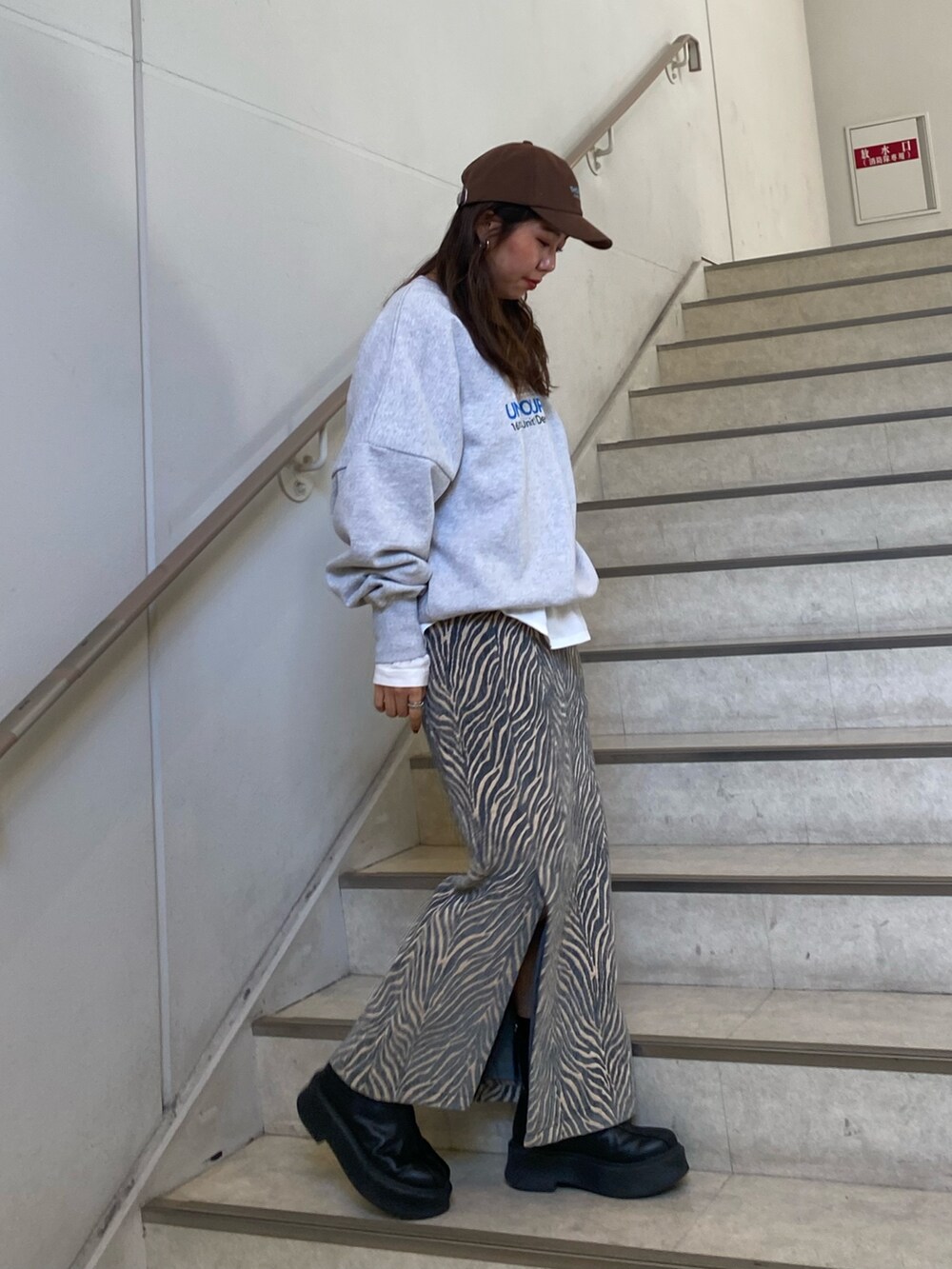 グレー系のスウェット、ブルー系のスカート、ホワイト系のTシャツ/カットソーを着用したレディースの冬コーディネートの3枚目の写真