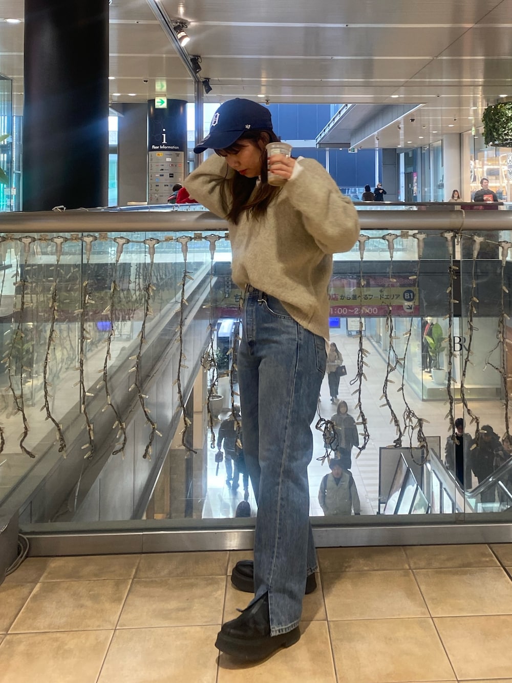 グレー系のニット/セーター、ブルー系のデニムパンツを着用したレディースの冬コーディネートの3枚目の写真